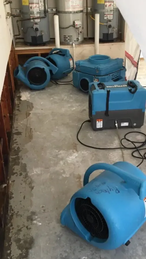 Blue air movers drying a wet League City floor