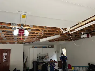 Water-damaged ceiling torn open from a leak above in a League City home